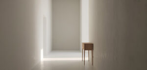 Ett fotorealistiskt foto av en ljus hall med vitmålade väggar och ett minimalistiskt träbord.