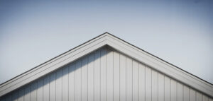 En fotorealistisk bild av en ny, ren träfasad med vit färg, med fokus på dess skyddande effekt och minimalistiska design.